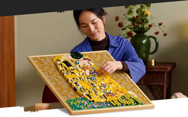 Kvinna i blå jacka sätter ihop Lego-version av Klimts